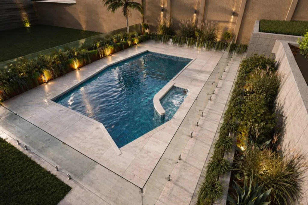 Luxury backyard swimming pool with ambient outdoor lighting and landscape design