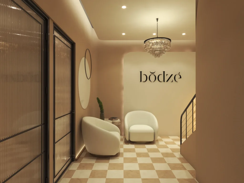Warm-toned spa lobby with luxury lounge chairs and decorative chandelier lighting.