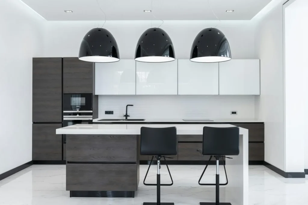 Modern kitchen interior in Melbourne with white island, dark cabinetry, and pendant lights