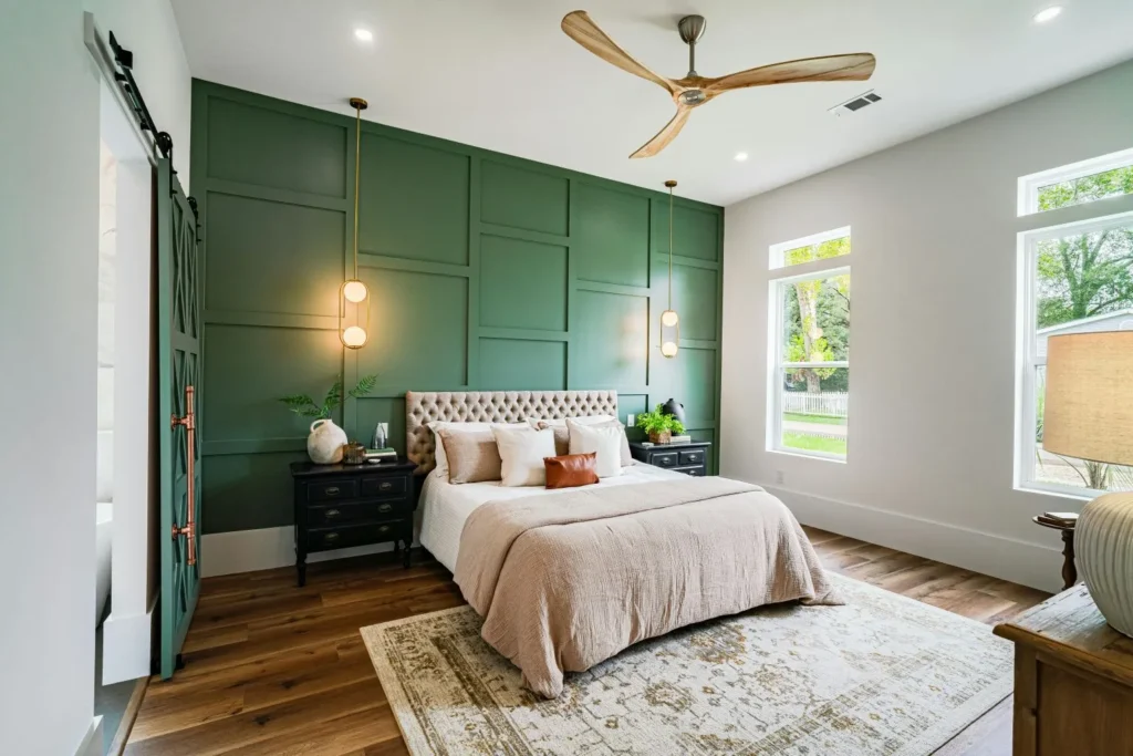 Interior Design Services Modern bedroom interior in Melbourne with tufted headboard, green accent wall, and pendant lights